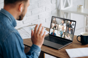 Video conference. Business partners communicate via video conference using laptop. The guy talks with his business partners appearance about plans and strategy. Distant work