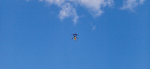 Hubschrauber fliegt vor blauem Himmel. Hubschrauber fliegt hoch oben. Helicopter flies high up.
Helicopter Flying against clear blue sky.