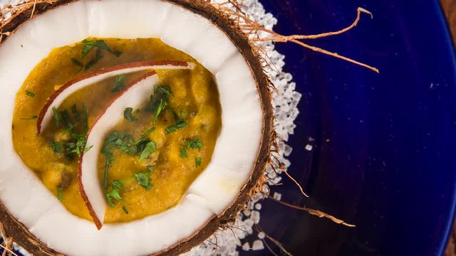 Sururu soup inside a coconut. Brazilian dish with smoke. Top view.