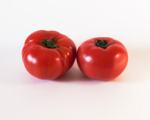 Cuatro tomates rojos maduros sobre fondo blanco 