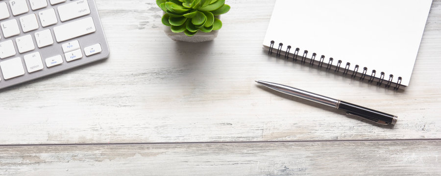 White desk office with laptop, smartphone and other work supplies with cup of coffee. Top view with copy space for input the text. Designer workspace on desk table essential elements on flat lay
