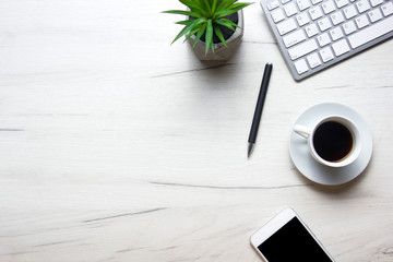 White desk office with laptop, smartphone and other work supplies with cup of coffee. Top view with copy space for input the text. Designer workspace on desk table essential elements on flat lay