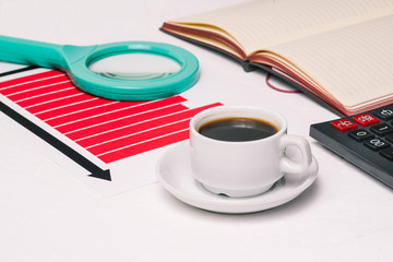 Office workplace with coffee Cup, calculator, magnifying glass and chart. Banking, investment and business.