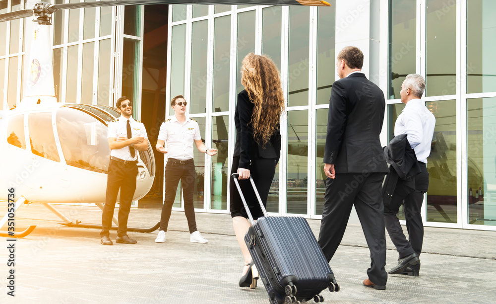 Canvas Prints group of business professionals in suit holding suitcases while walking towards a parked helicopter 