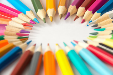 Multi сolored pencils arranged around,isolated on white background .Selective focus.Copy space