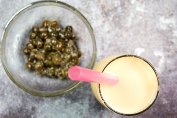 Obraz na płótnie Canvas Flatlay bokeh of pearl milk tea with tapioca ball or bubble tea insight.