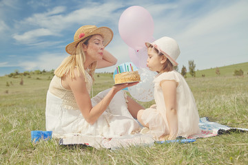 Mother and daughter celebrating birthday in nature park 