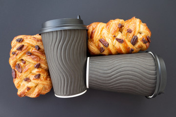 Coffee to go concept. Disposable black cup with spiral texture with black plastic cover and maple pecan on a trendy grey background. Place for text. Flat lay style. Top view