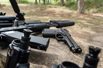 Obraz premium Laserwar or lasertag weapon replica of military rifle and gun rifles on the bench in day in nature close up
