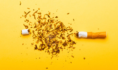 31 May of World No Tobacco Day, no smoking, close up of broken pile cigarette or tobacco STOP symbolic on yellow background with copy space, and Warning lung health concept