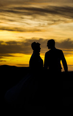 Fototapeta na wymiar At sunset, a girl and a man. Love look.
