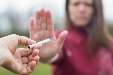 girl refuses a cigarette. woman quits smoking. bad habit.  World No Tobacco Day. human arm is...
