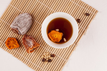 Sujeonggwa - Korean iced tea. Dark reddish brown in color, it is made from gotgam (dried persimmon) and ginger and is often garnished with pine nuts
