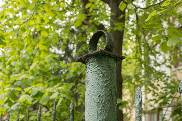 Green metal fence in the park. Road fence