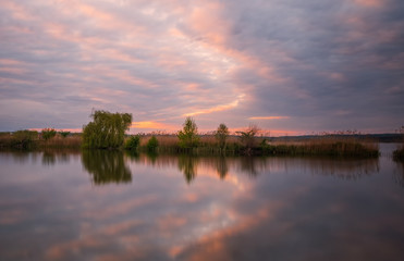 Fototapeta premium Long exposure sunset view on Ivano-Frankove (Yaniv), Yanivskyi Stav Lake and forest. Roztochia Biosphere Reserve, Lviv district, Ukraine. May 2020