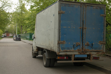 An old, rusty truck stands on the road.