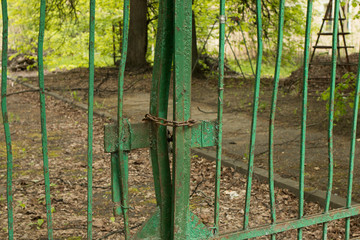 Old metal fence closed on a chain and padlock.