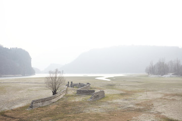 ruins on the river on a foggy morning near Arsiè