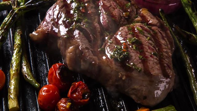 Ancho steak with grilled vegetables on the grill. Top view with smoke.