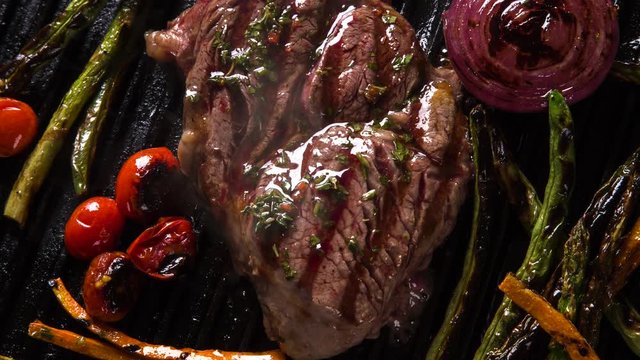 Ancho steak with grilled vegetables on the grill. Top view with smoke.
