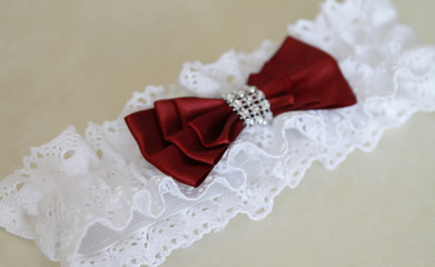 Woman's garter on a red background. Bride accessories. Stylish blue wedding.