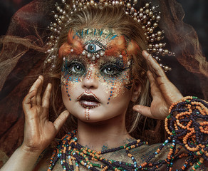 close up portrait of beautiful ethnic colorful girl with big crown of beads. professional creative  makeup. face painting