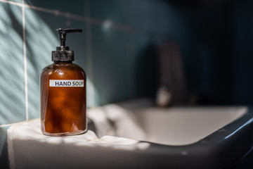 Close up hand wash liquid soap bottle have sun light only shines on it, which it stand on the sink...