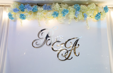 Wedding background in the hall with flowers and letters.
