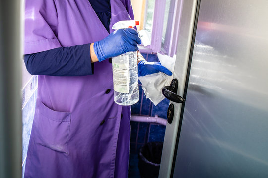 Janitor Cleaning Lady Cleaning Door Handle With Alcohol In The Office Building.