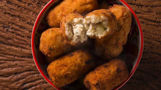 Cod fritters, traditional Spanish tapas Bunuelos de Bacalao with smoke. Top view.