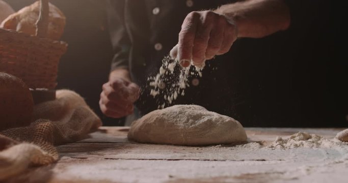 Professional mature caucasian baker forming loaf of bread dough with passion, retired pensioneer enjoying his new hobby, isolated on black background 4k footage