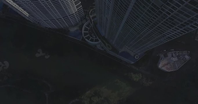 Ungraded, Back away aerial flight from high rise building tilting up to reveal metropolitan city's skyline. Drone, 4K.
