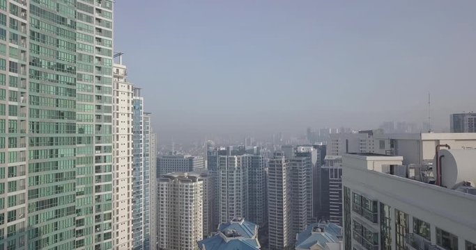 Ungraded, Morning Aerial flight towards Urban City over High Rise Buildings. Drone, 4K.