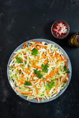 White cabbage salad coleslaw with carrot on grey kitchen table background. Top view, copy space