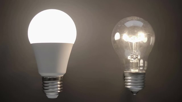 Energy-saving, eco-friendly Led bulb lamp compared to a classic glass tungsten filament lamp are lights up on a black background. Closeup