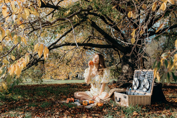 Happy Woman Life Style, beautiful asian girl on the nature picnic with fruits. Relaxing asian woman in Nature. Autumn landscape background. Active Outdoor Relax in Nature.