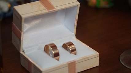 Golden rings in the background a red casket.