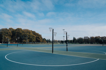 Netball goal ring and net against a blue sky and clouds at Hagley park, Christchurch, New zealand. - obrazy, fototapety, plakaty