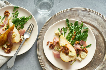 Pear salad with walnuts, prosciutto, arugula and blue cheese. Dinner appetizer