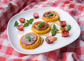 Caprese italienisch mit saftigen Tomaten, Zucchini, Basilikum und Essig und Öl wie in Italien mit Tischdecke