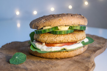 Veganer Burger mit knusprigem Kichererbsen-Patty vor Lichterkette