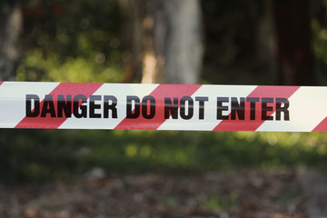 Danger do not enter tape in a public park blocking the exercise equipment at the time of covid 19 pandemic