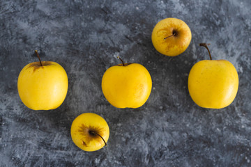 plant-based ingredients, group of golden delicious apples with smaller and bigger sizes on concrete...