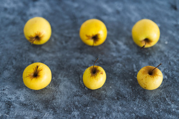 plant-based ingredients, group of golden delicious apples with smaller and bigger sizes on concrete...
