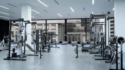 Fototapeta na wymiar Empty modern gym interior with sports equipment, heavy gym equipment arranged inside modern fitness club.