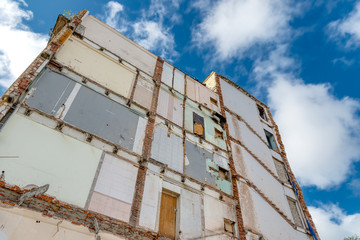 The high wall of the destroyed building against the blue sky