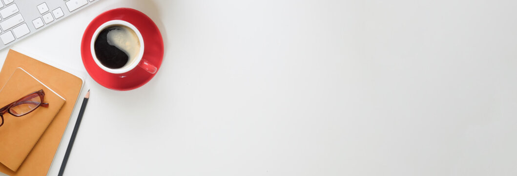 Top view office stuff with notepad, laptop and coffee cup mouse notepad shot.blank screen mobile phone and supplies on white desk workspace and copy space.