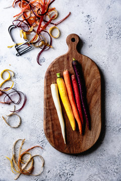 Rainbow carrots on a wooden cutting board.