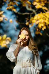Beautiful asian woman with autumn leaves, flower and fall yellow leaves background at Hagley park, Christchruch, New Zealand.