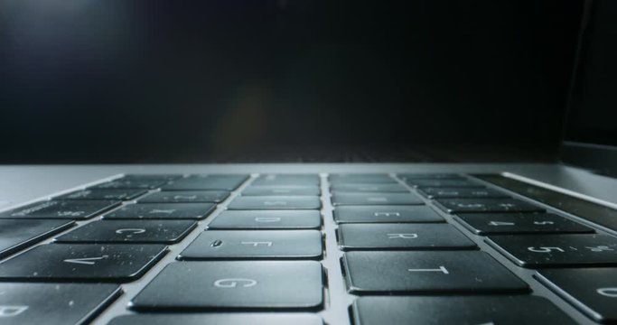 Close up zoom in shot of keyboard buttons of laptop computer, isolated on black background - technology, computers concept 4k footage